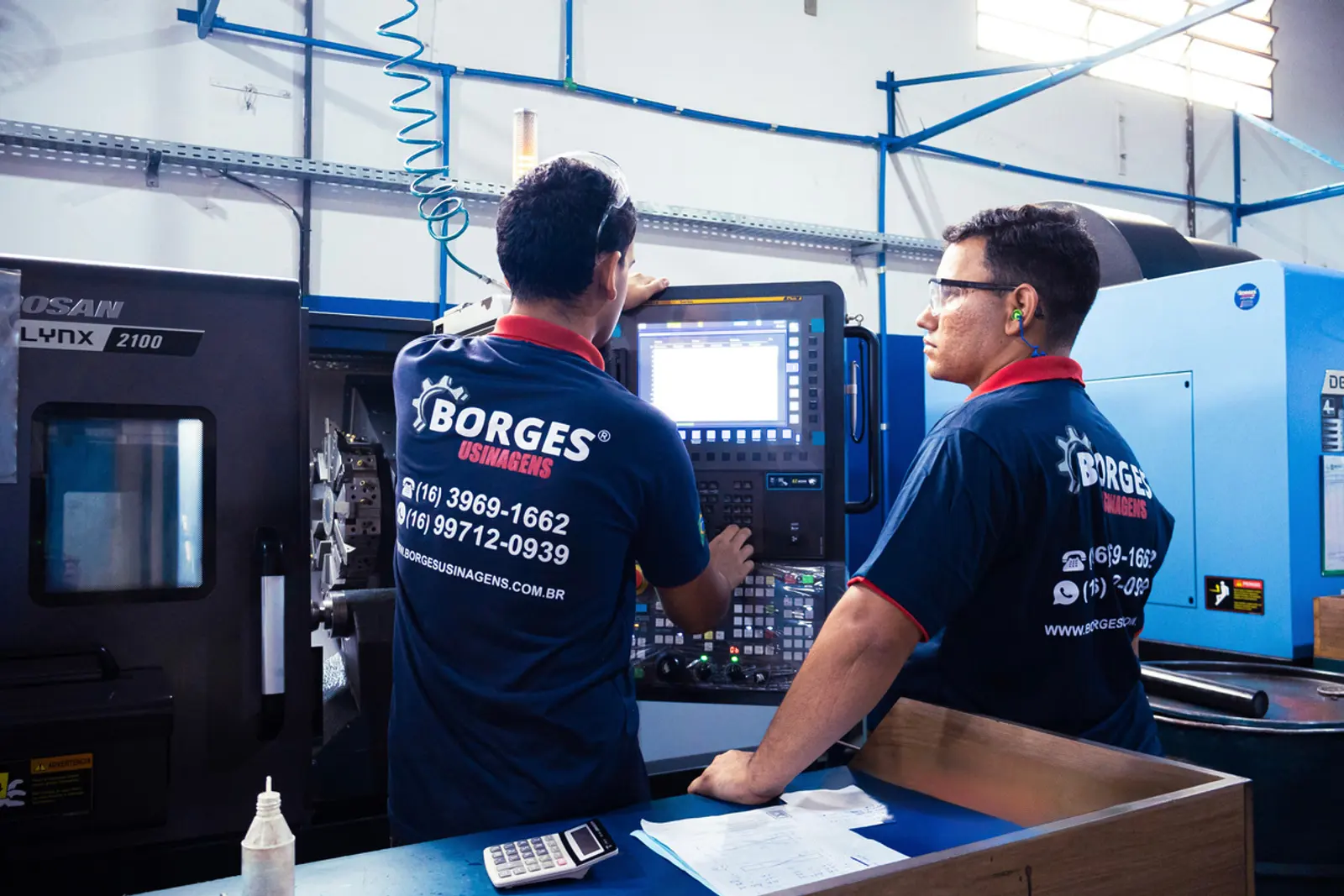Operadores da Borges Usinagens analisando o painel do centro de usinagem